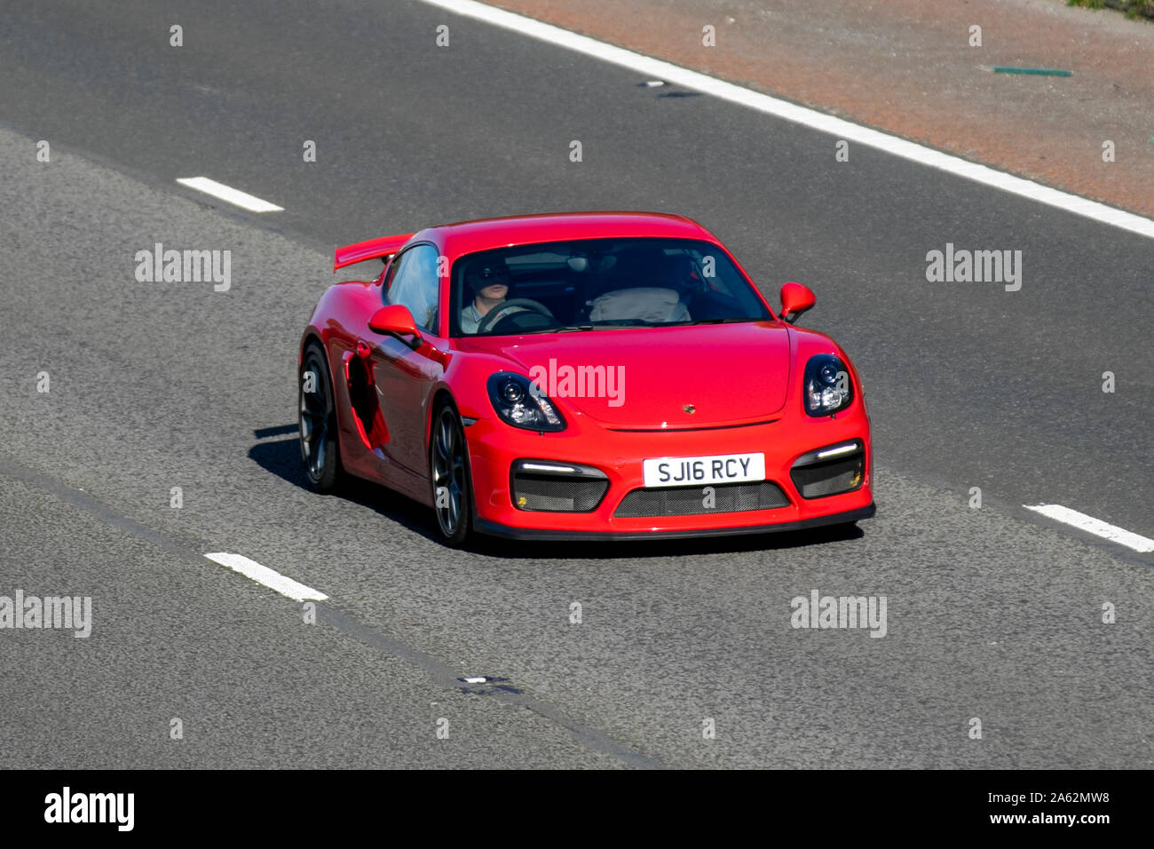 2016 red Porsche Cayman GT4; Regno Unito il traffico veicolare, trasporti, moderno, carrozze salone, sud-legato sulla corsia di 3 M6 motorway autostrada. Regno Unito Foto Stock