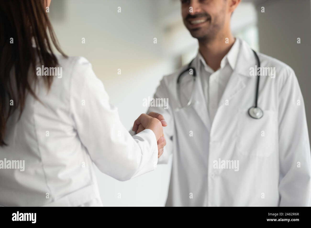 Il team medico medico maschio e femmina infermiera agitare le mani Foto Stock