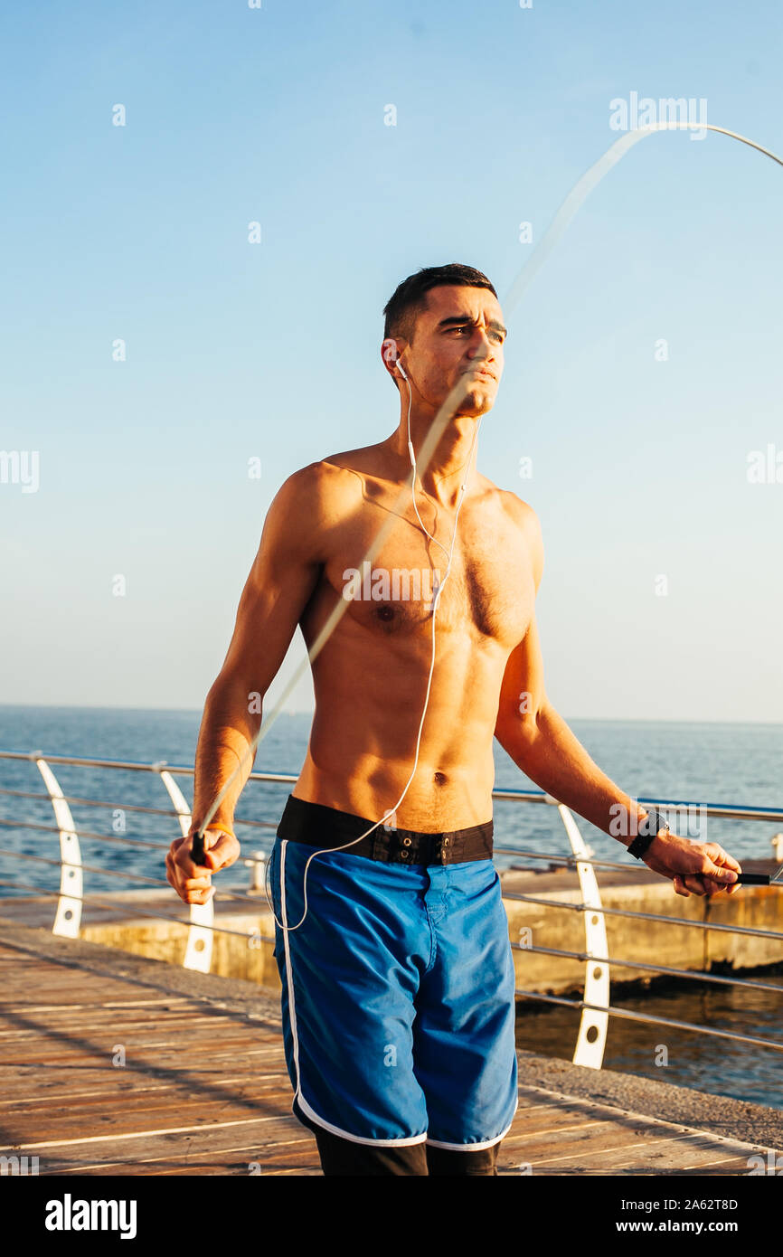 Montare uomo bello il riscaldamento con salto con la corda in preparazione  per un allenamento eseguito Foto stock - Alamy