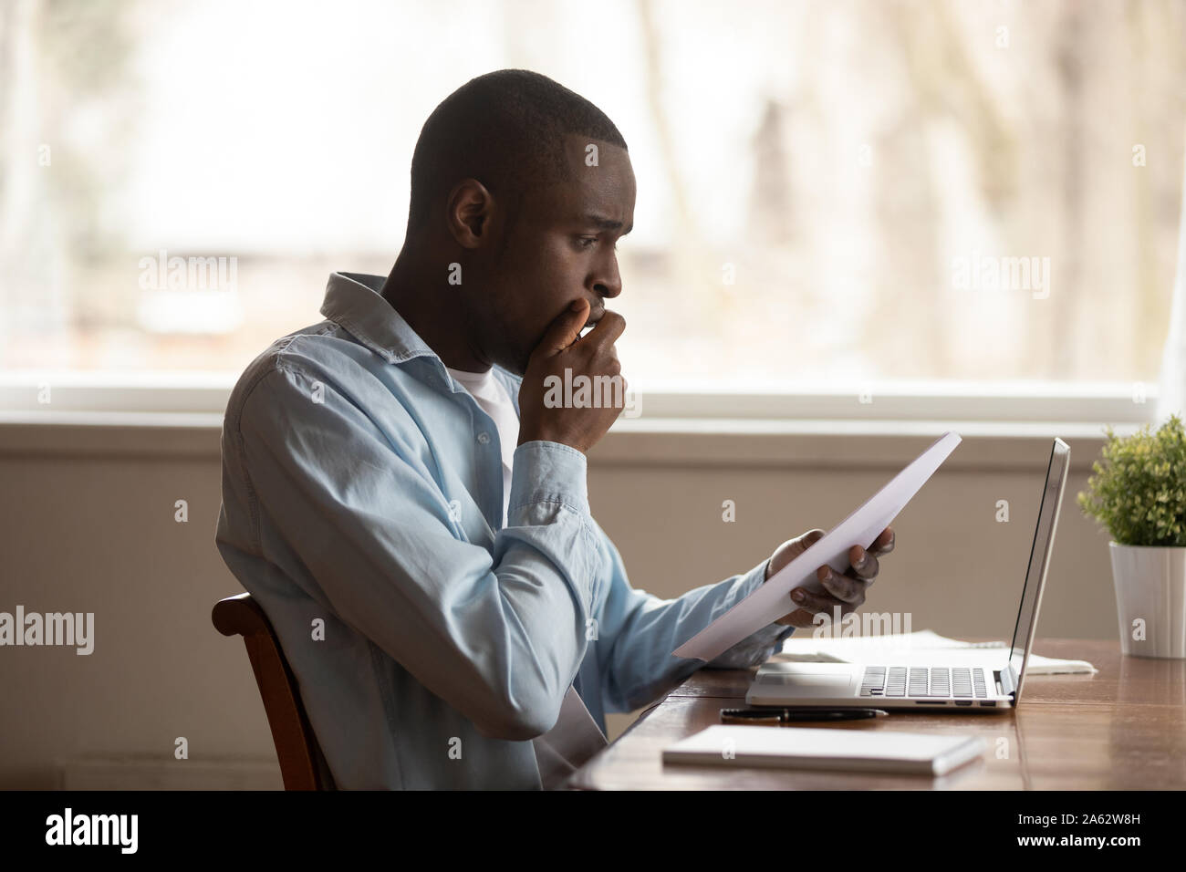 Infelice giovane africana ragazzo americano grande ricevuto notifica di debito. Foto Stock
