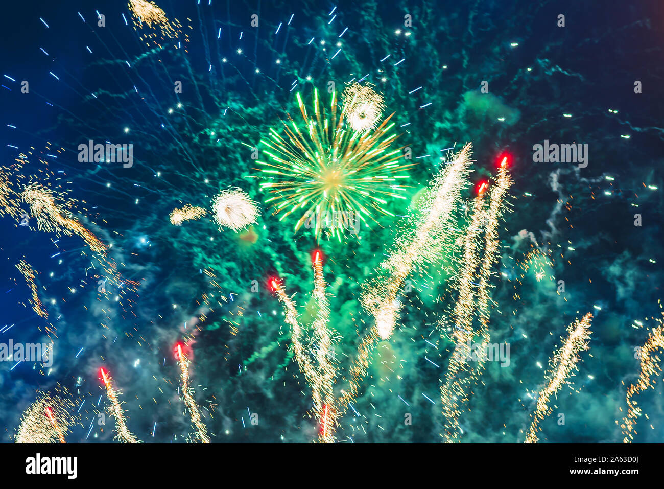 Poco costoso fuochi d'artificio sopra la città di rosso, verde e giallo sul cielo blu. Luminoso e brillante. Per qualsiasi scopo. Celebrazione del concetto. Foto Stock