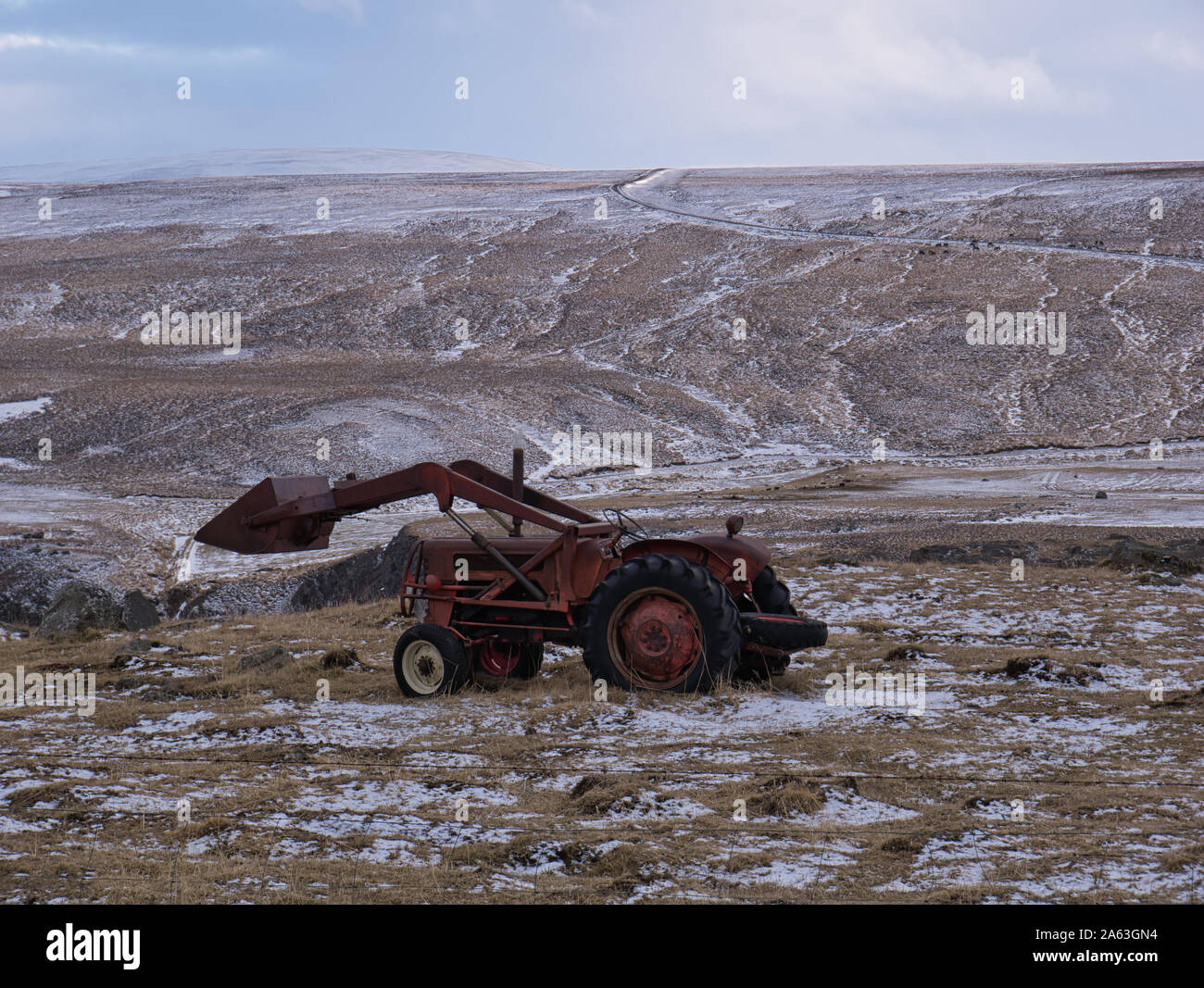 Un vecchio trattore con caricatore frontale su un prato in Islanda Foto Stock