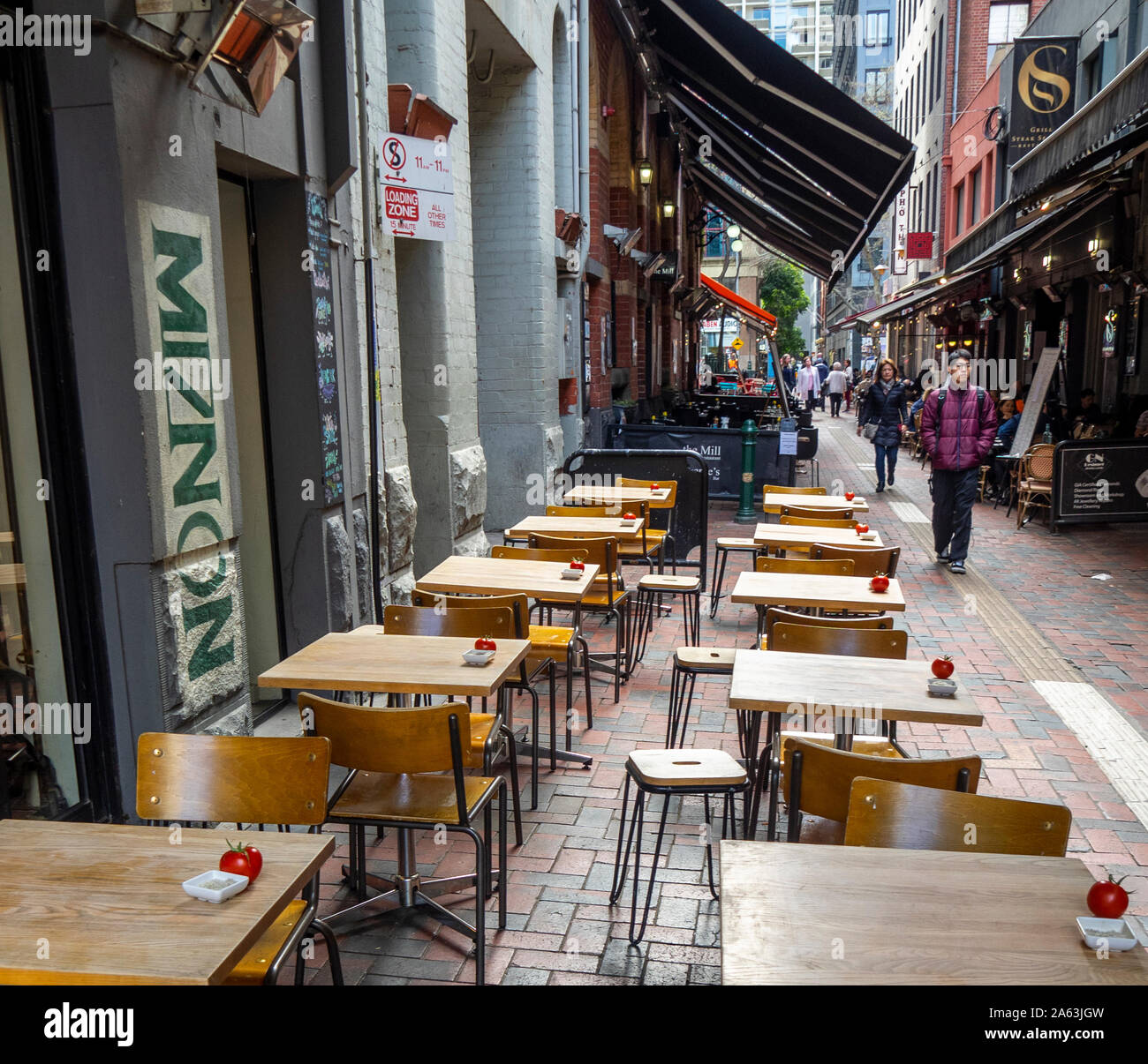 Tavoli in legno con un pomodoro nell'angolo pasti al fresco in Hardware Lane Melbourne Victoria Australia. Foto Stock