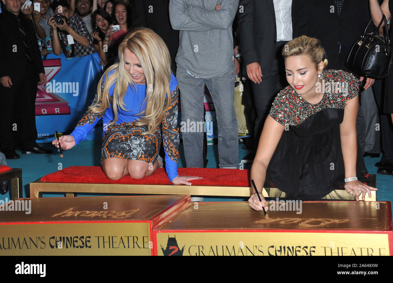 LOS ANGELES, CA. 11 settembre 2012: Britney Spears & Demi Lovato (a destra) durante la stagione due premiere di 'X Factor USA'. Essi e gli altri giudici hanno avuto il loro handprints impostato in cemento ad Grauman's Chinese Theater di Hollywood. © 2012 Paul Smith / Featureflash Foto Stock