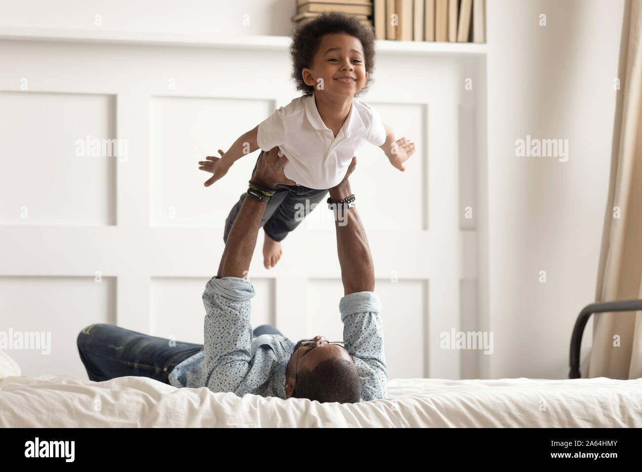 African American dad giocando con il figlio dei bimbi in camera da letto Foto Stock