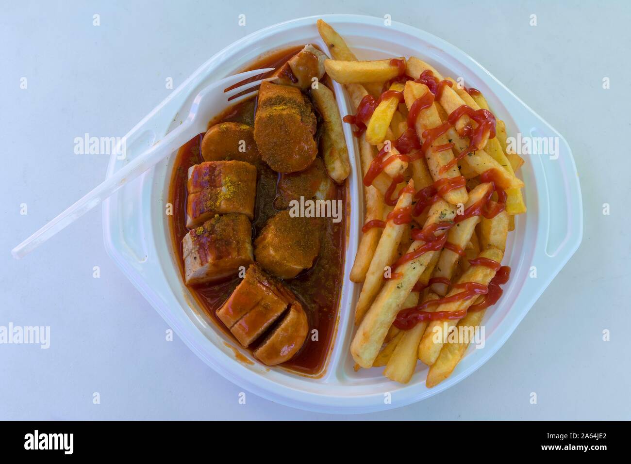 Currywurst con patatine fritte con forcella di plastica su una piastra di plastica, un fast food, Germania Foto Stock