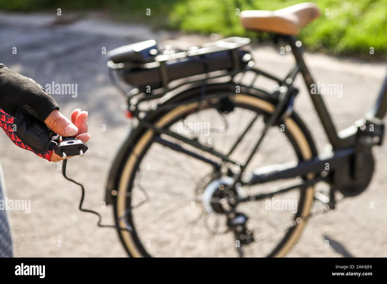 Ciclista pronti per collegare la batteria su una bicicletta elettrica, Belgio Foto Stock