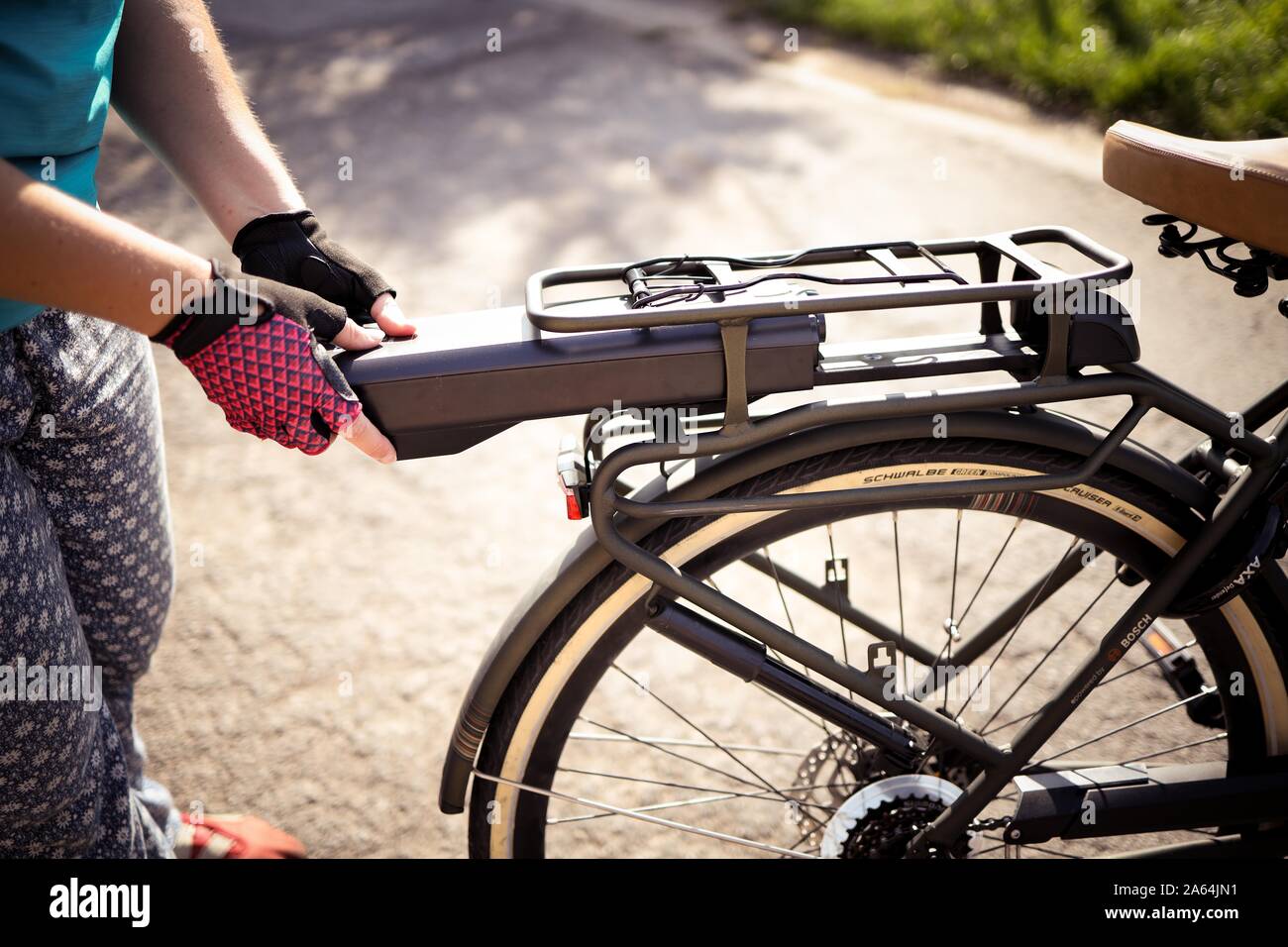 Ciclista inserendo la batteria su una bicicletta elettrica, Belgio Foto Stock