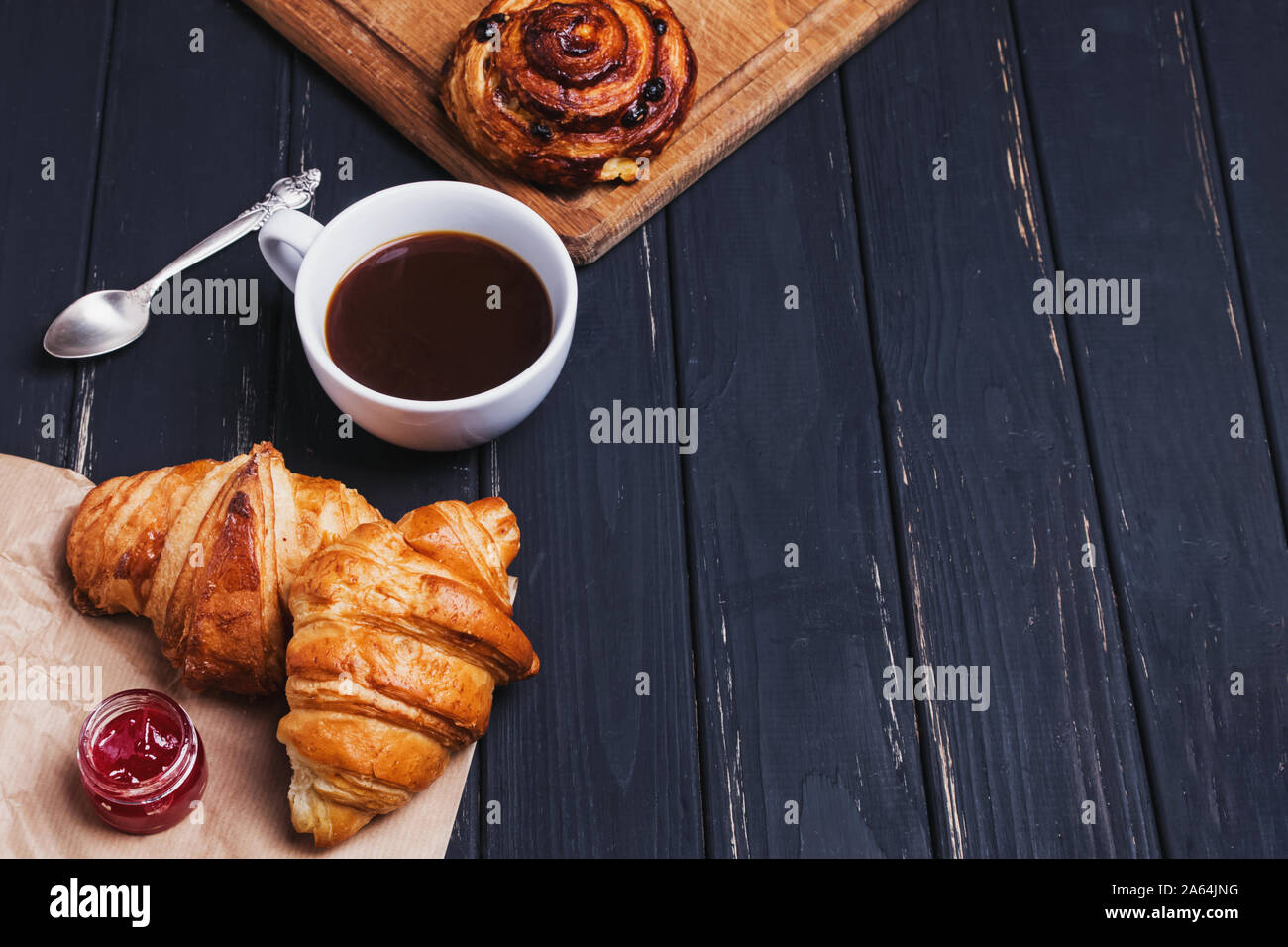 Caffè e cornetti freschi sulla tavola nera Foto Stock