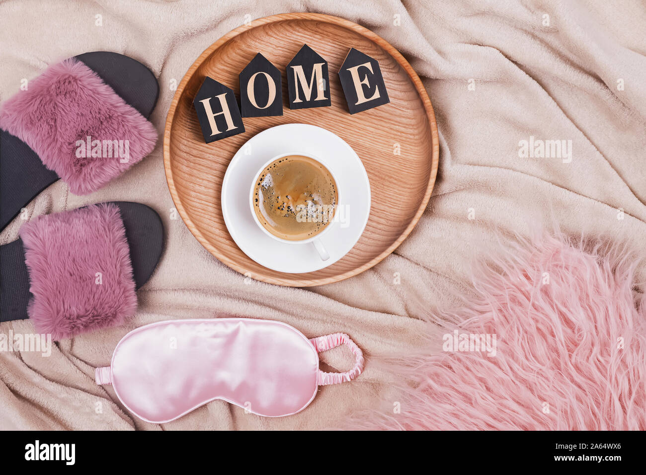 Composizione creativa con caffè, pantofole, slittamento maschera e lettere di legno disposte in una parola Home Foto Stock