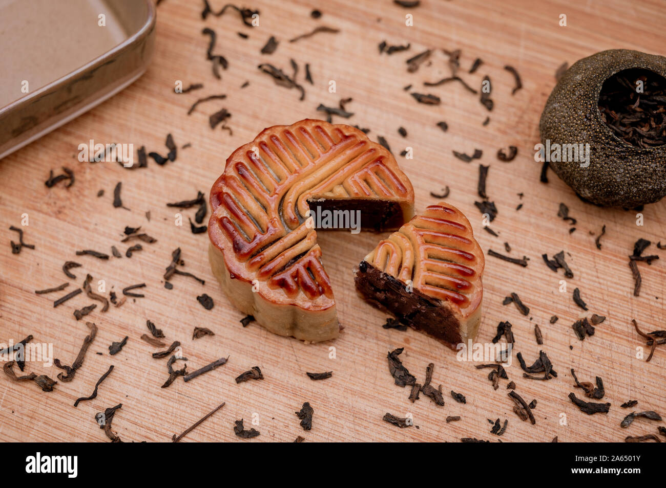 Preparazione al concetto del festival cinese di metà autunno. Cibo tradizionale per la vacanza deliziosa torta Moon sul vassoio di legno con il tè nero pu`er. Foto Stock