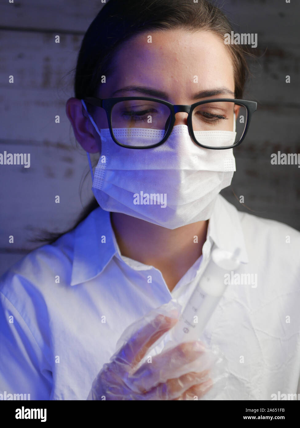 Close up di un infermiere. Medico infermiere, dietro la maschera di un chirurgo. Closeup ritratto di una giovane donna caucasica modello indossando occhiali nero Foto Stock