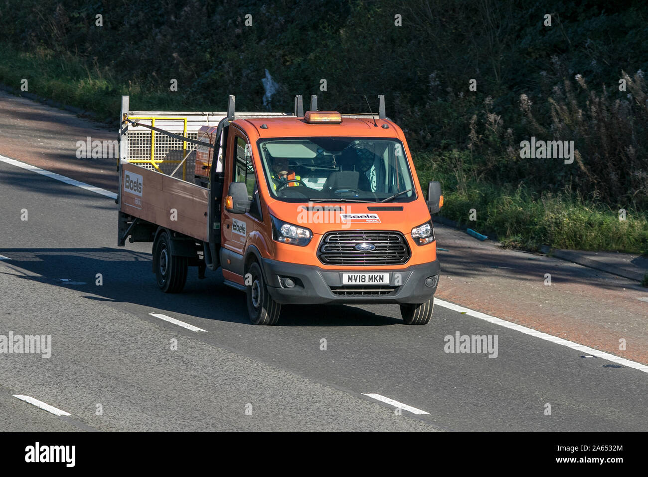 Noleggio Boels Ford Transit dropside flatbed veicolo che viaggia sull'autostrada M6 vicino a Preston nel Lancashire, Regno Unito Foto Stock