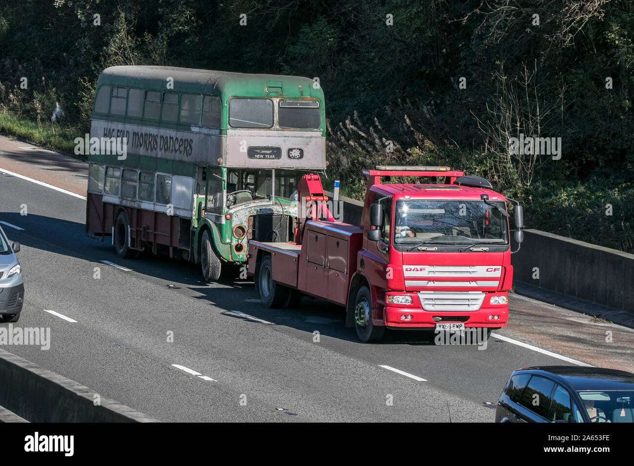 DAF CF il traino di vecchio fienile arrugginito trovare double decker bus Viaggiare sulla autostrada M6 vicino a Preston nel Lancashire, Regno Unito Foto Stock