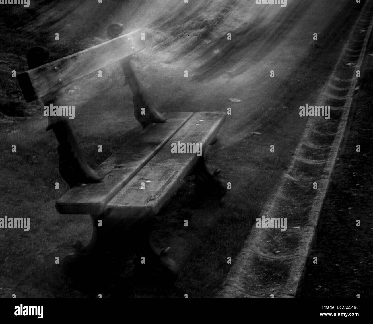 Una panchina nel parco di notte con swishing luce come uno spirito di lasciare il posto di guida Foto Stock