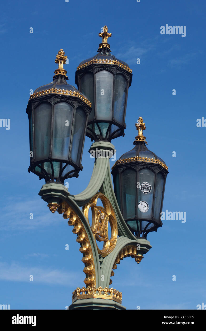 Tre lampade impostato su un lam post sul Westminster Bridge, Londra che mostra il dettaglio ornati in lamiera e lampade contro un profondo cielo blu Foto Stock