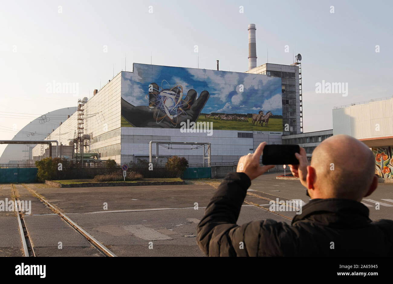 Kiev, Ucraina. 23 Ott, 2019. Un uomo prende una foto di un murale gigante chiamato 'guardando al futuro dell' autore Valerii Korshunov che è visto in un edificio di centrale nucleare di Cernobyl. Credito: SOPA Immagini limitata/Alamy Live News Foto Stock