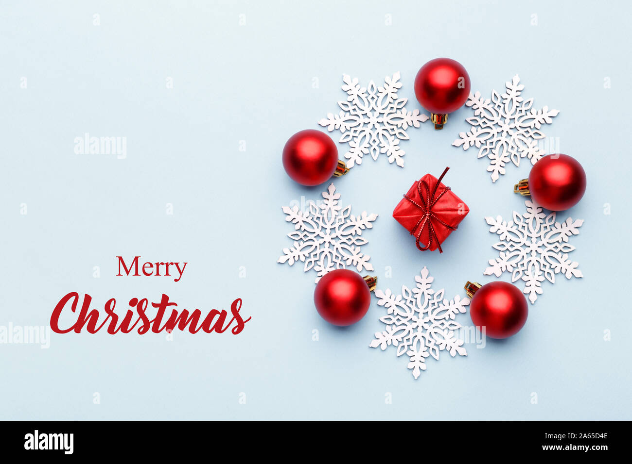 Natale palle rosse e fiocchi di neve su blu sullo sfondo alla moda con i messaggi di saluto Foto Stock