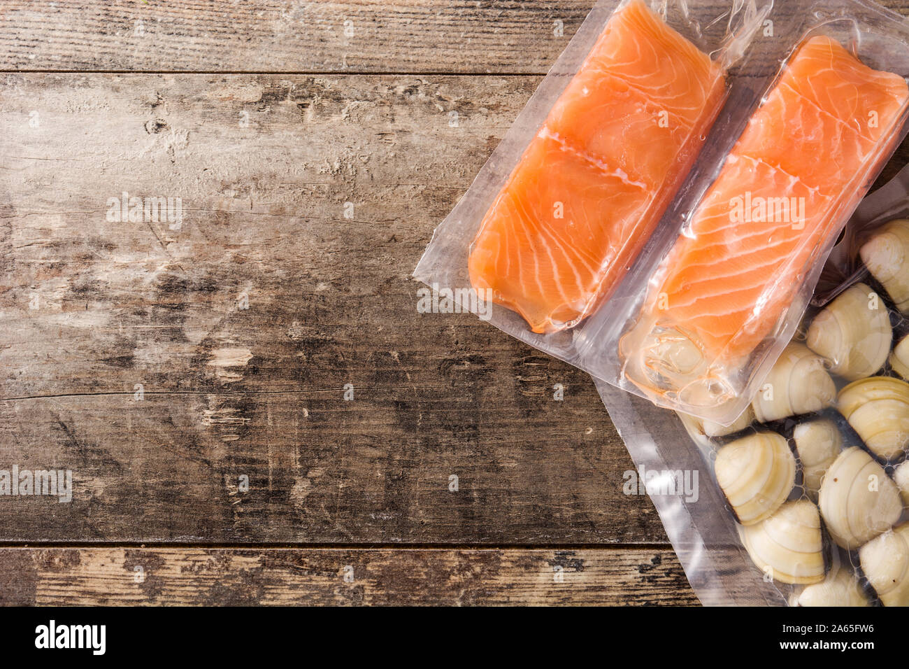 Il salmone confezionato in plastica su un tavolo di legno. Vista superiore Foto Stock
