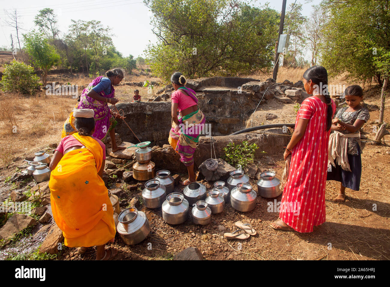 Le donne a raccogliere acqua dal bene al villaggio vicino Shahapur, Mumbai, Maharashtra, India, Asia Foto Stock