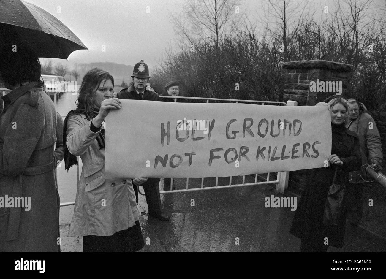 Sheila Clifford (l) e Barbara Rawlinson in piedi sotto la pioggia con un banner di protesta al di fuori Brimington crematorio, Chesterfield, dove William Hughes - l'assassino di massa shot dalla polizia come ha tenuto una donna ostaggio - è stato cremato. *WIREPHOTO Foto Stock