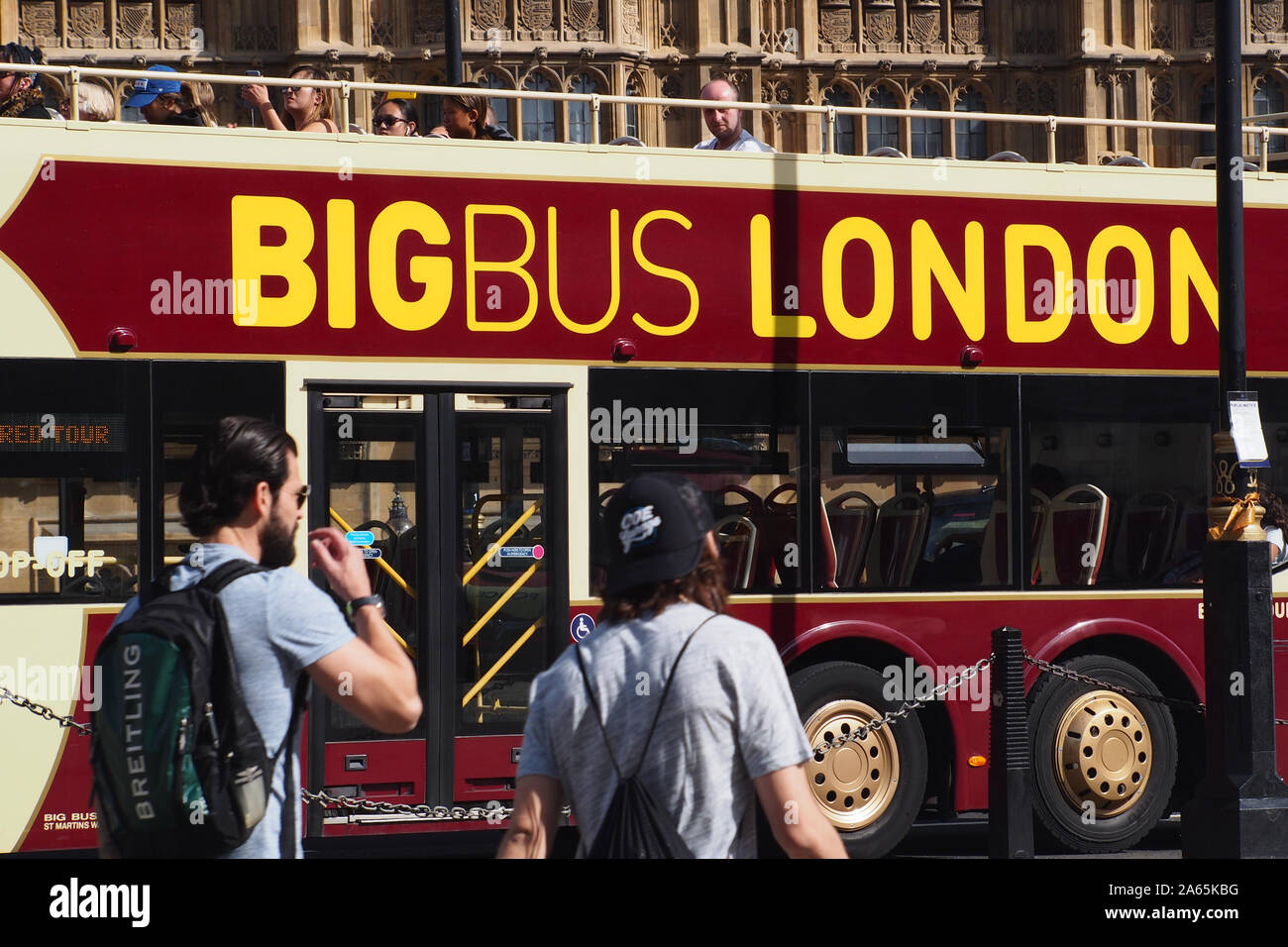 Una vista ravvicinata di un autobus aperto sul tetto su un viaggio turistico intorno a Londra passando per le Case del Parlamento, Westminster, London, con passeggeri Foto Stock