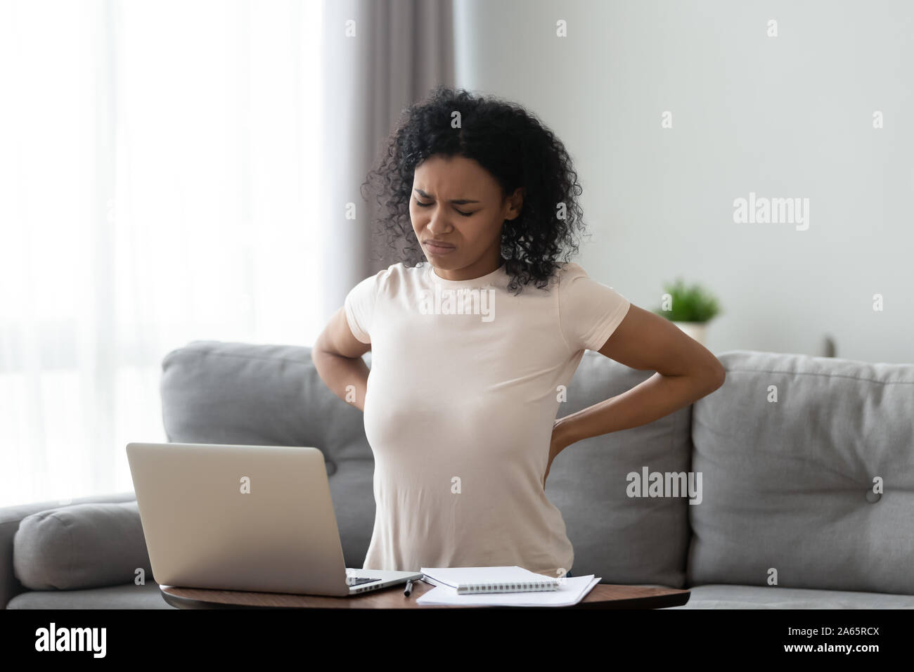 Malsana nero donna stretching che soffrono di mal di schiena Foto Stock