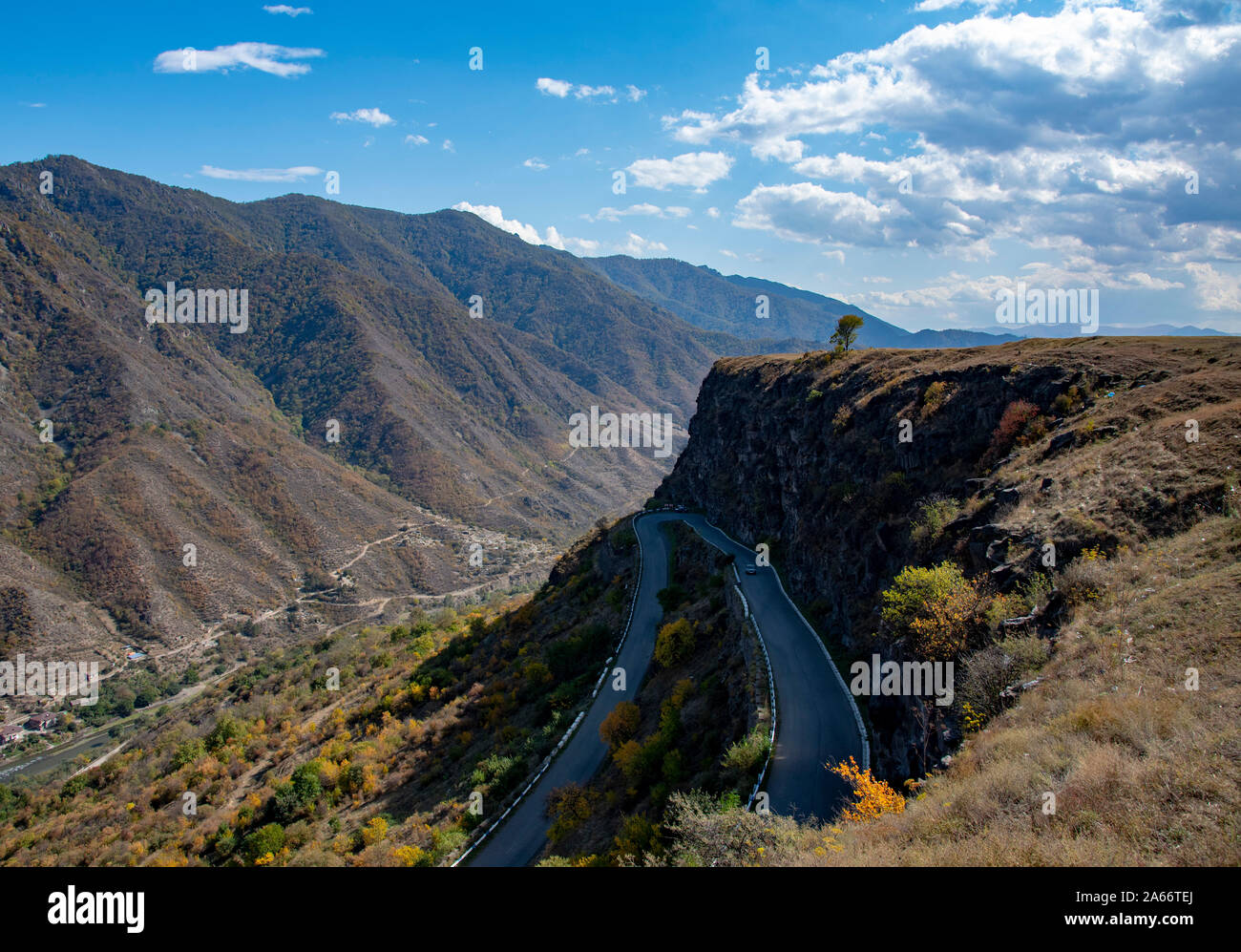 Serpentina di strada in montagna sotto un cielo nuvoloso. Foto Stock