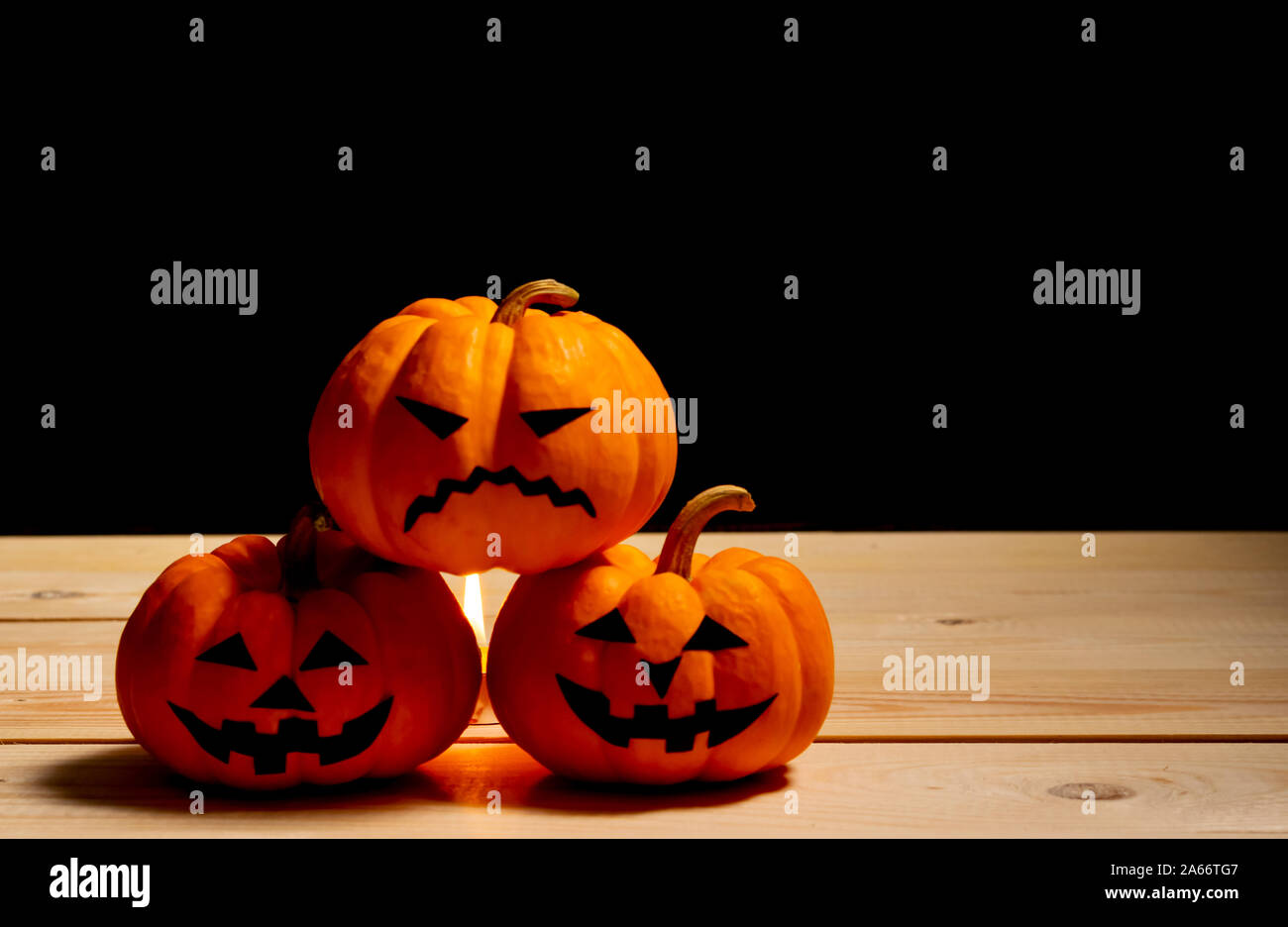 Concetto di Halloween. arancione zucca jack o lantern decor con facce buffe su sfondo nero. Foto Stock
