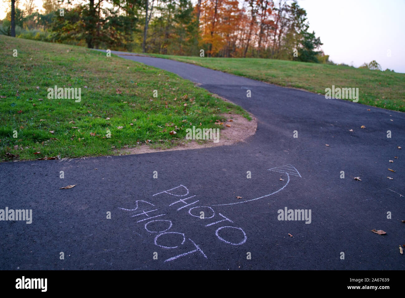 Foto riprese chalk marcature sul parco asphalt trail dirigere i modelli verso la posizione di ripresa. Foto Stock