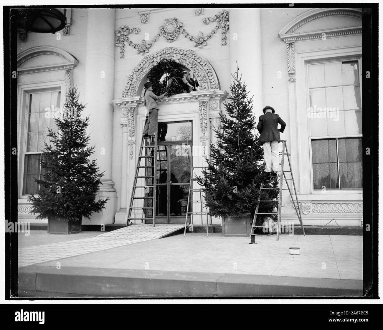 Casa bianca prende il vestito di Natale. Washington D.C., dic. 19. Gli operai erano alacremente impegnati oggi mettere le decorazioni di Natale sulla parte anteriore della Casa Bianca. Le decorazioni sono accesi con gayly luci colorate per la Vigilia di Natale al tempo stesso il presidente Roosevelt preme l'interruttore per la luce della comunità albero di Natale Foto Stock
