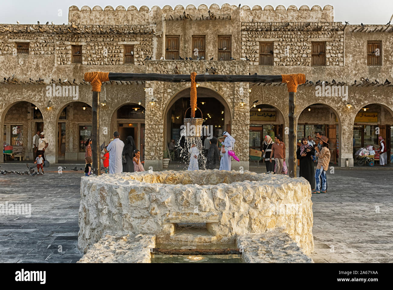 Doha,Qatar-March 30,2018: Souk Waqif marketplace in Doha vista diurna con vecchio pozzo fontana in primo piano Foto Stock