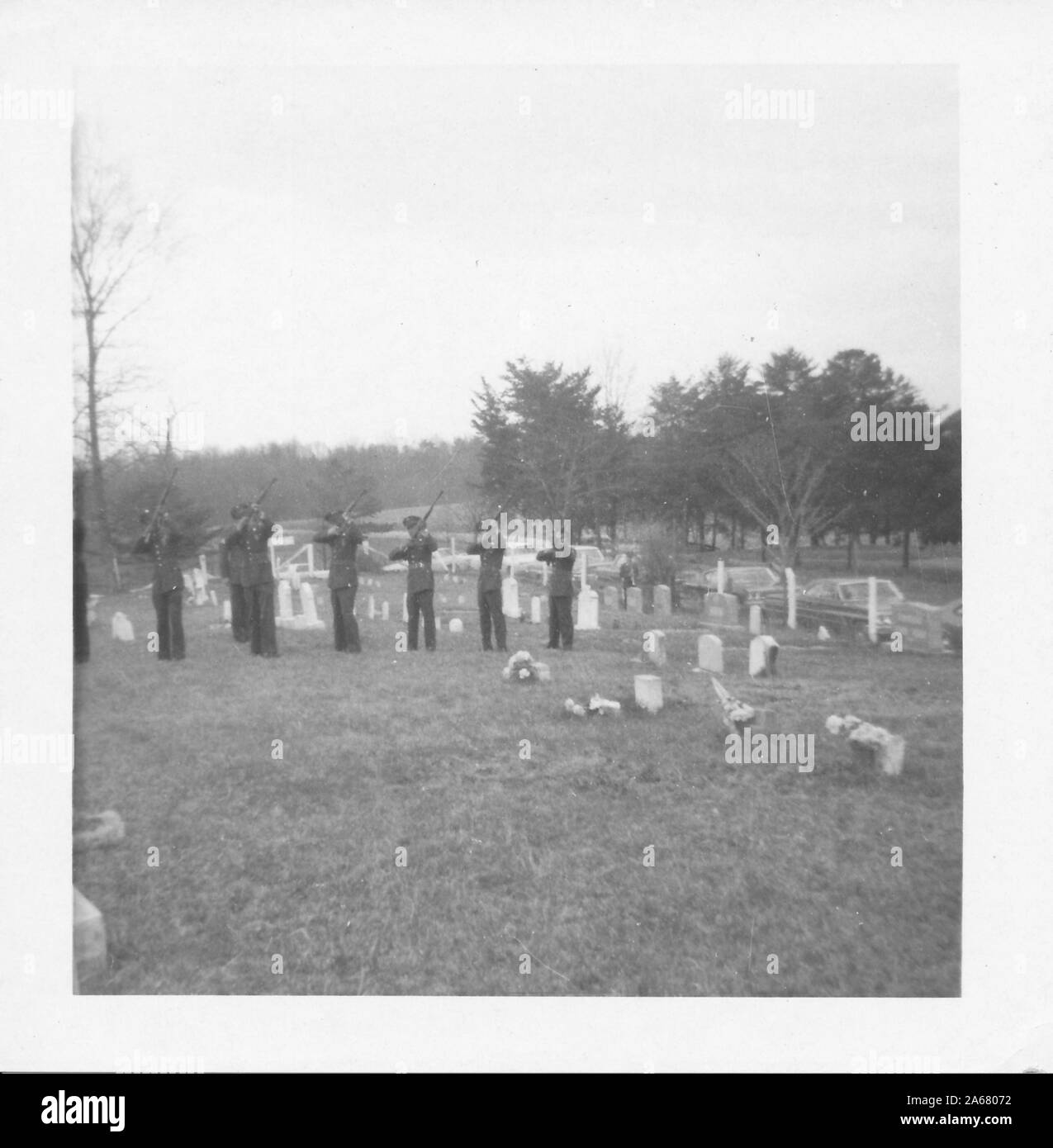 Una fila di serviceman americani, in piedi in un cimitero in una giornata gettata, indicando i loro fucili nel cielo durante un funerale militare, Stati Uniti d'America, fotografato durante la guerra del Vietnam, 1965. () Foto Stock