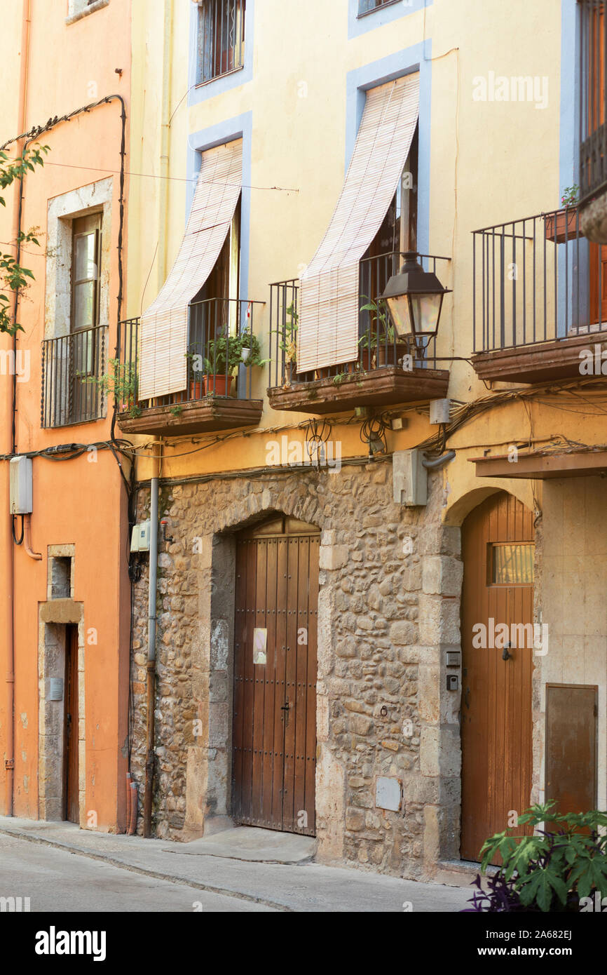 Balconi su un vecchio edificio in pietra in Spagna, al secondo piano. La  paglia persiane abbassate per proteggere dal luminoso sole estivo Foto  stock - Alamy