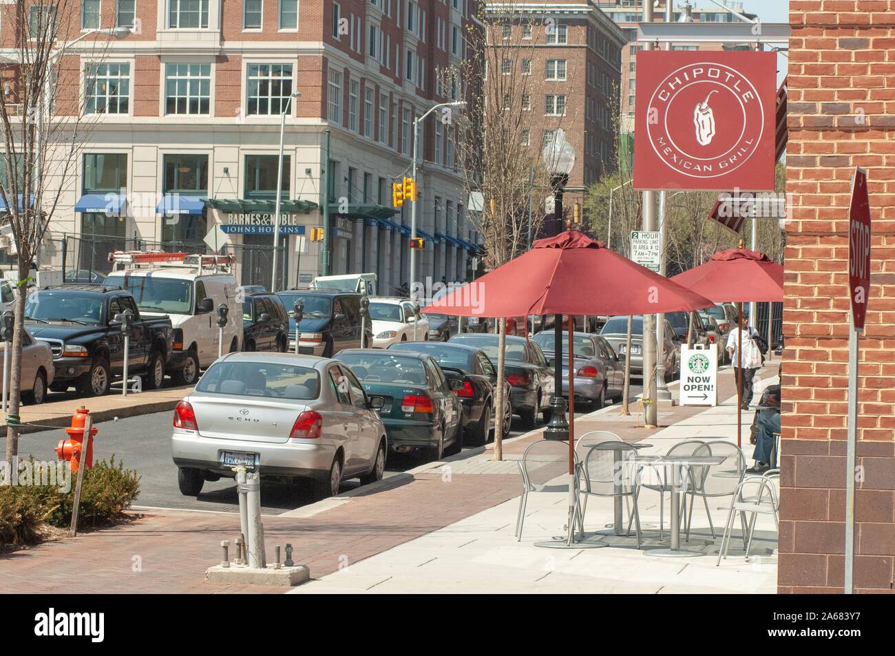 Vista ad angolo di una strada urbana una giornata di sole, con segni pubblicitari Barnes e Noble, Chipotle, e Starbucks, nelle vicinanze della Johns Hopkins University, Baltimora, Maryland, 23 aprile 2007. Dalla Homewood Photography Collection. () Foto Stock