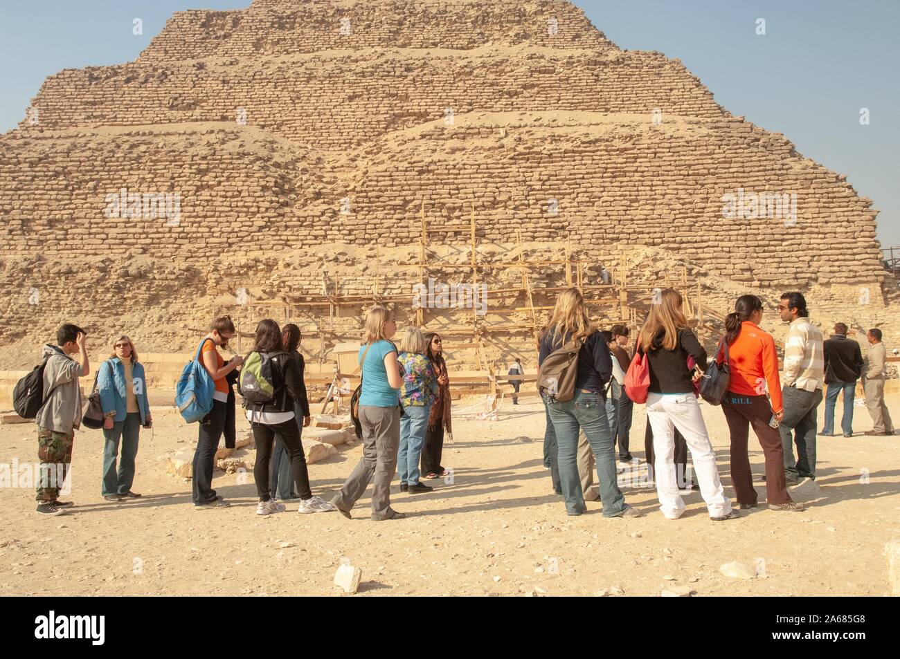 Un gruppo di studenti della Johns Hopkins University di Baltimore, Maryland, fuori in una giornata di sole, in piedi vicino a una piramide con impalcature in legno alla base di Giza in Egitto durante un programma di studio all'estero, 6 gennaio 2008. Dall'Homewood raccolta di fotografie. () Foto Stock