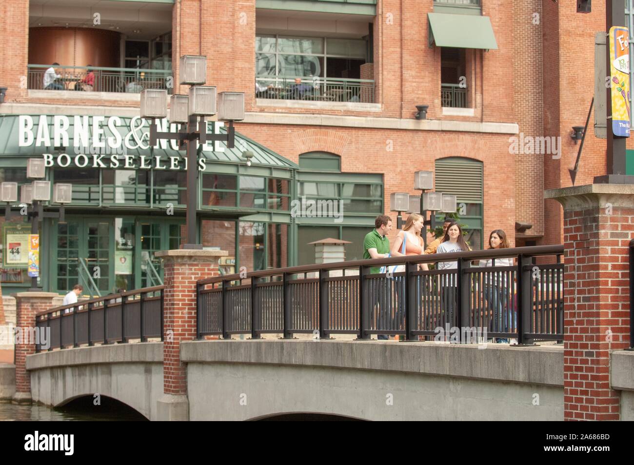 Johns Hopkins University gli studenti, camminando su un ponte vicino a Barnes and Noble nel convertito Pratt Street Power Plant complesso, Porto Interno di Baltimore, Maryland, maggio 2008. Dall'Homewood raccolta di fotografie. () Foto Stock