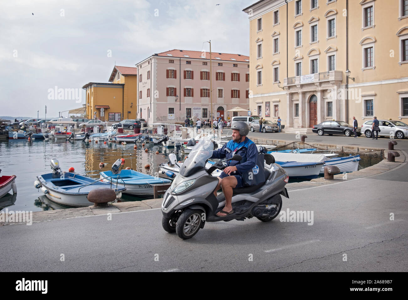 Un uomo di mezza età su una ruota di tre corse in moto lungo il litorale adriatico a Pirano, Slovenia. Foto Stock