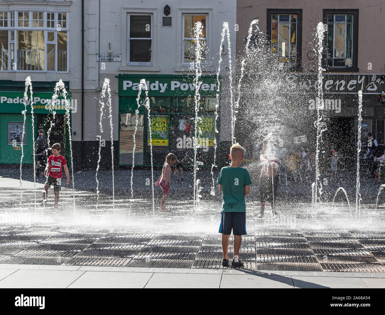 I bambini giocano nelle fontane pubbliche su una calda giornata di Liverpool Foto Stock