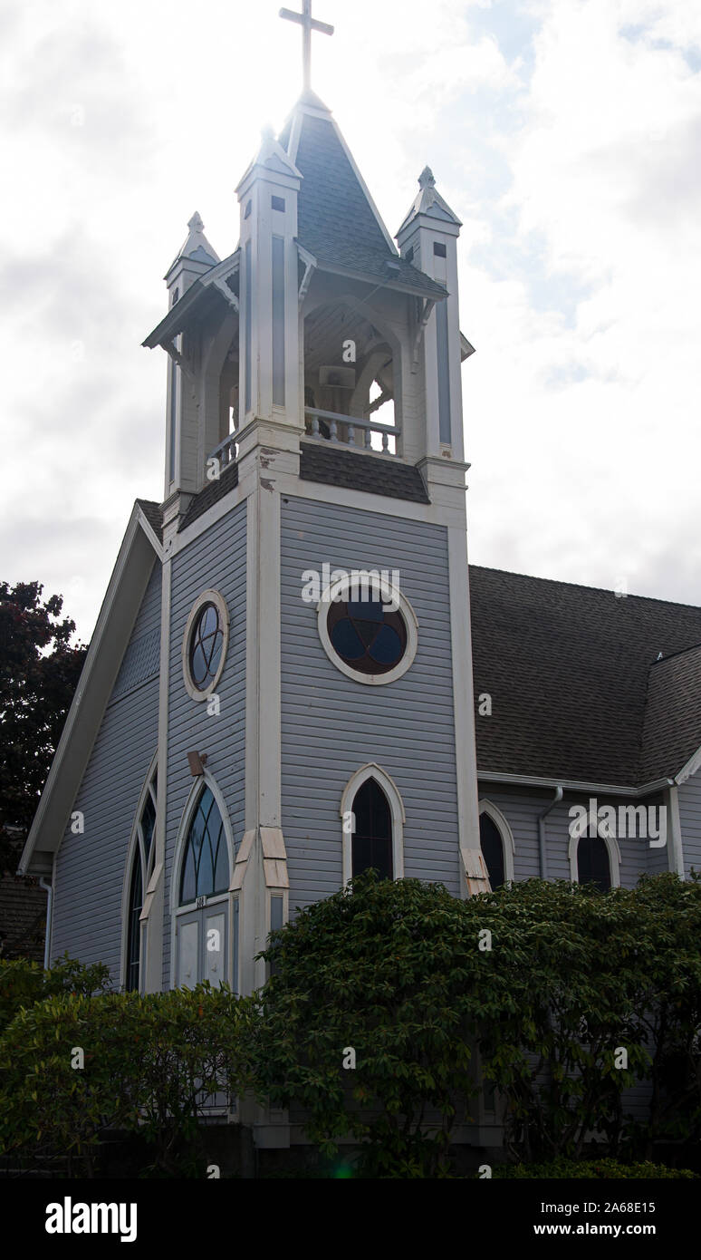 Chiesa Vintage con il sole brilla backlit dietro un cross in area di steeple, trovati in Coupeville, Washington. Foto Stock