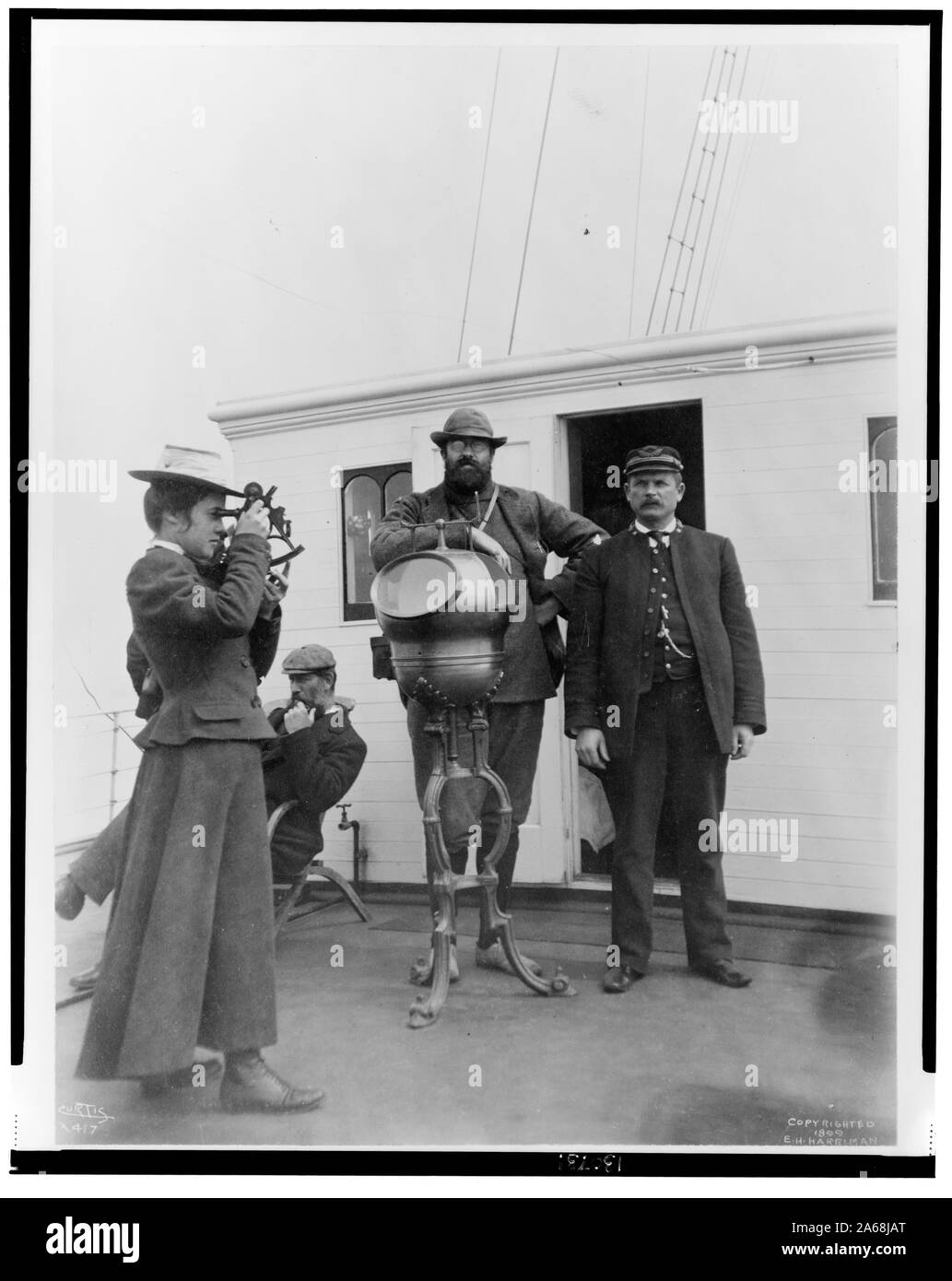 Donna che guarda attraverso il sestante a bordo della nave della spedizione, George W. sambuco, con due uomini e il cap. Peter Doran durante Harriman spedizione in Alaska, 1899] / Curtis Foto Stock