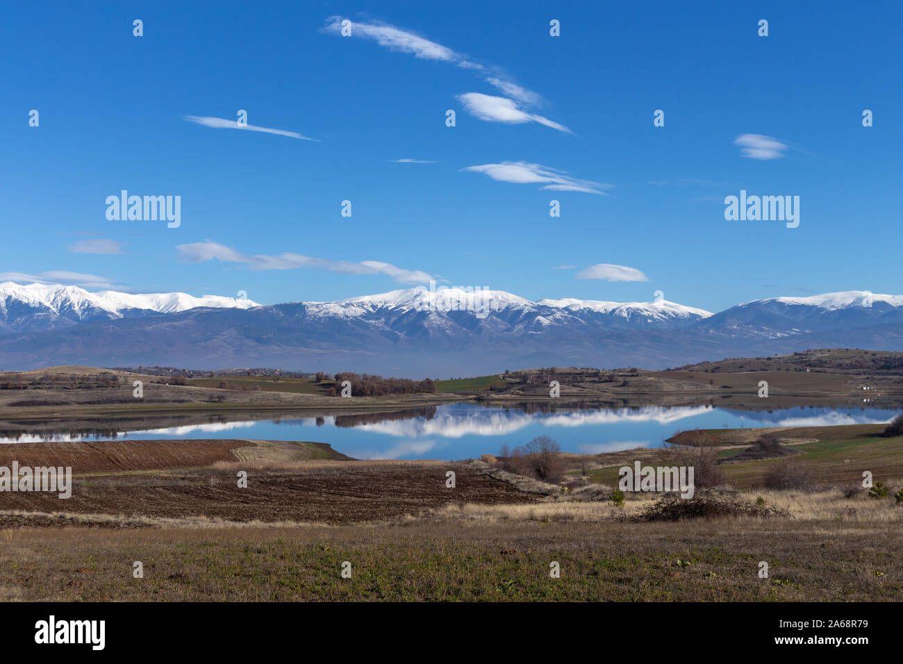 Vista delle montagne innevate con la riflessione nel lago (Rila, Bulgaria) Foto Stock