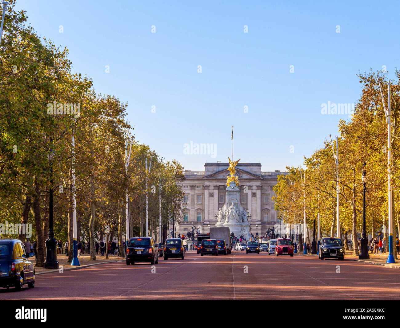 Taxi sul Mall, con Buckingham Palace in background e dorate autunnali alberi colorati, Londra, Regno Unito. Foto Stock