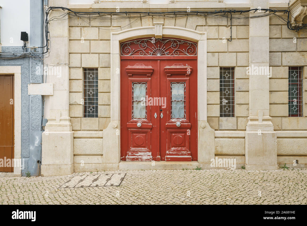 Rosso porta in legno e muro di mattoni in una città antica street, Lagos, Portogallo Foto Stock