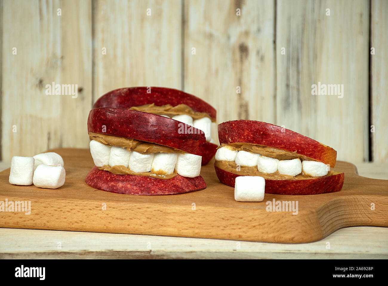 Apple Halloween labbra e denti di marshmallow con burro di arachidi sul pannello di legno Foto Stock