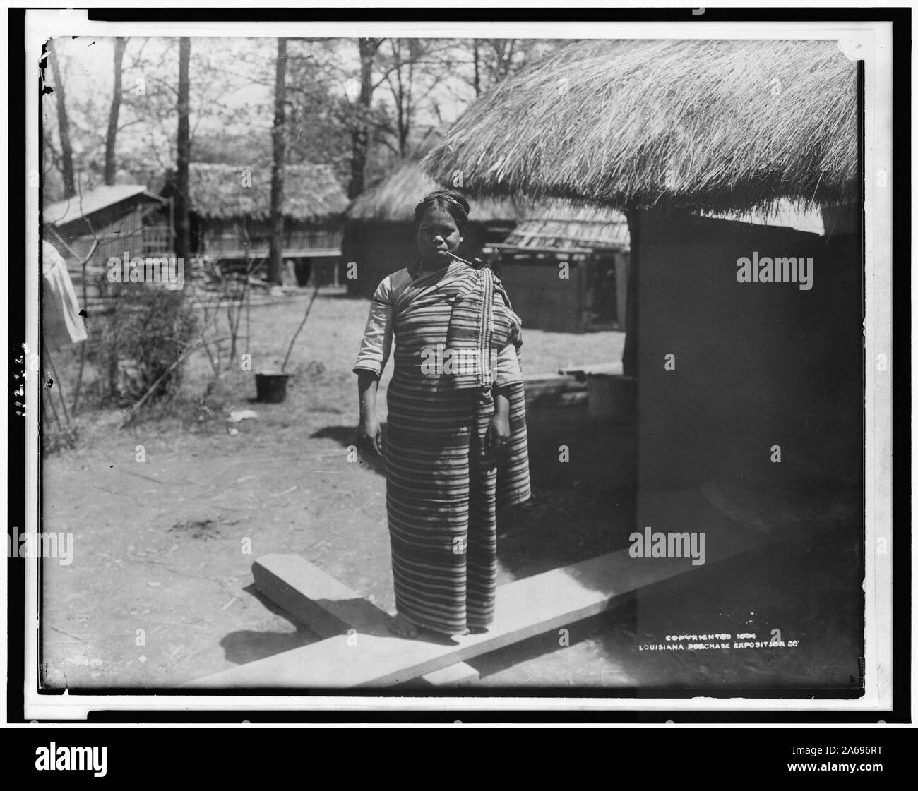 Giovane donna in abiti tradizionali, tubo di fumo, nel villaggio di Igorot della Louisiana Purchase Exposition Foto Stock