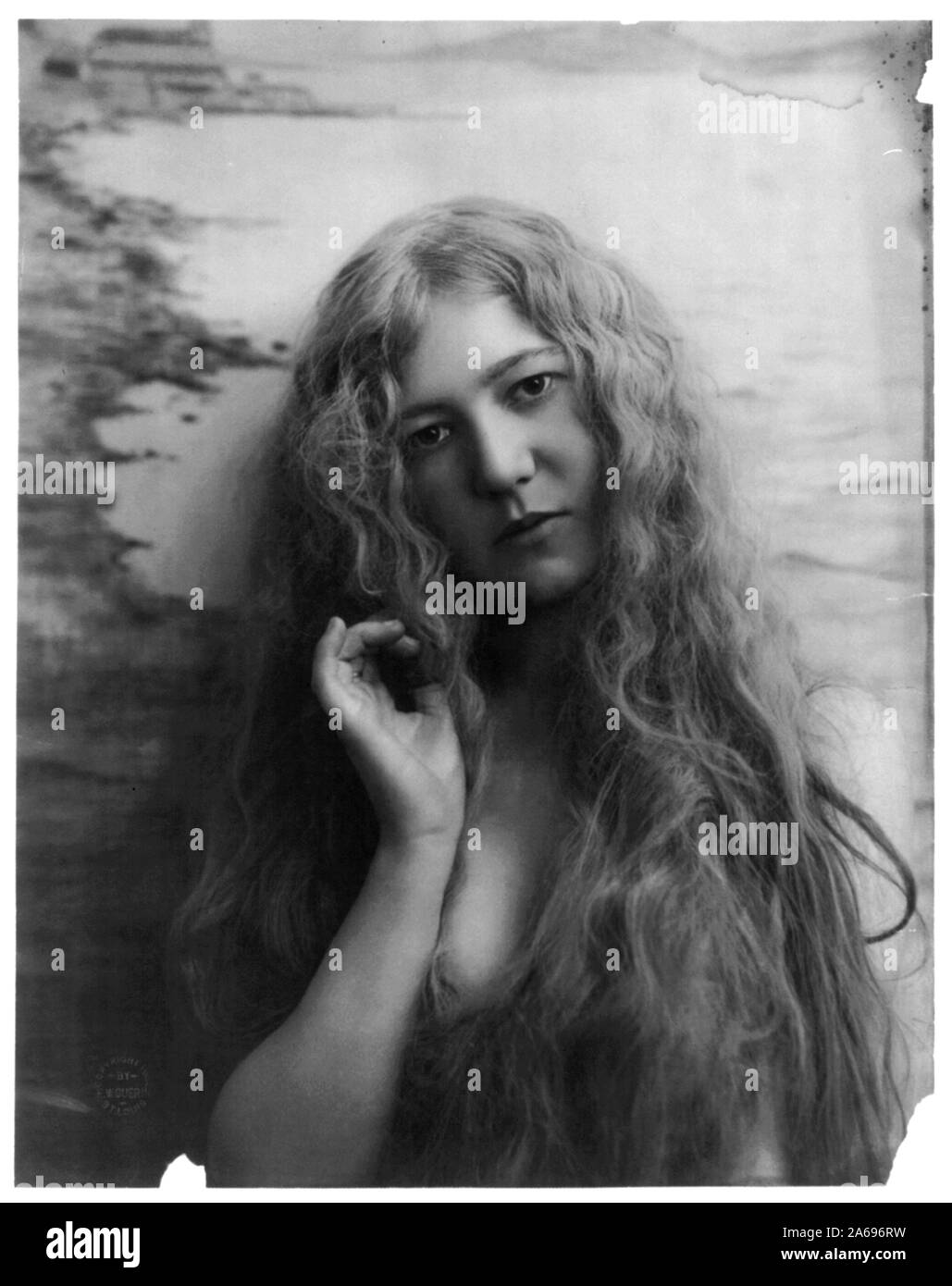 Giovane donna di modellazione: testa e spalle, con peli molto lunghi, lato destro sollevato verso la testa Foto Stock