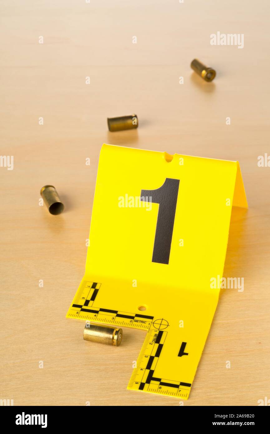 Crime Scene Investigation CSI prova marker con vuoto, sparò 9mm involucri punto sul pavimento in legno background sulla scena del crimine - polizia, prove o per Foto Stock
