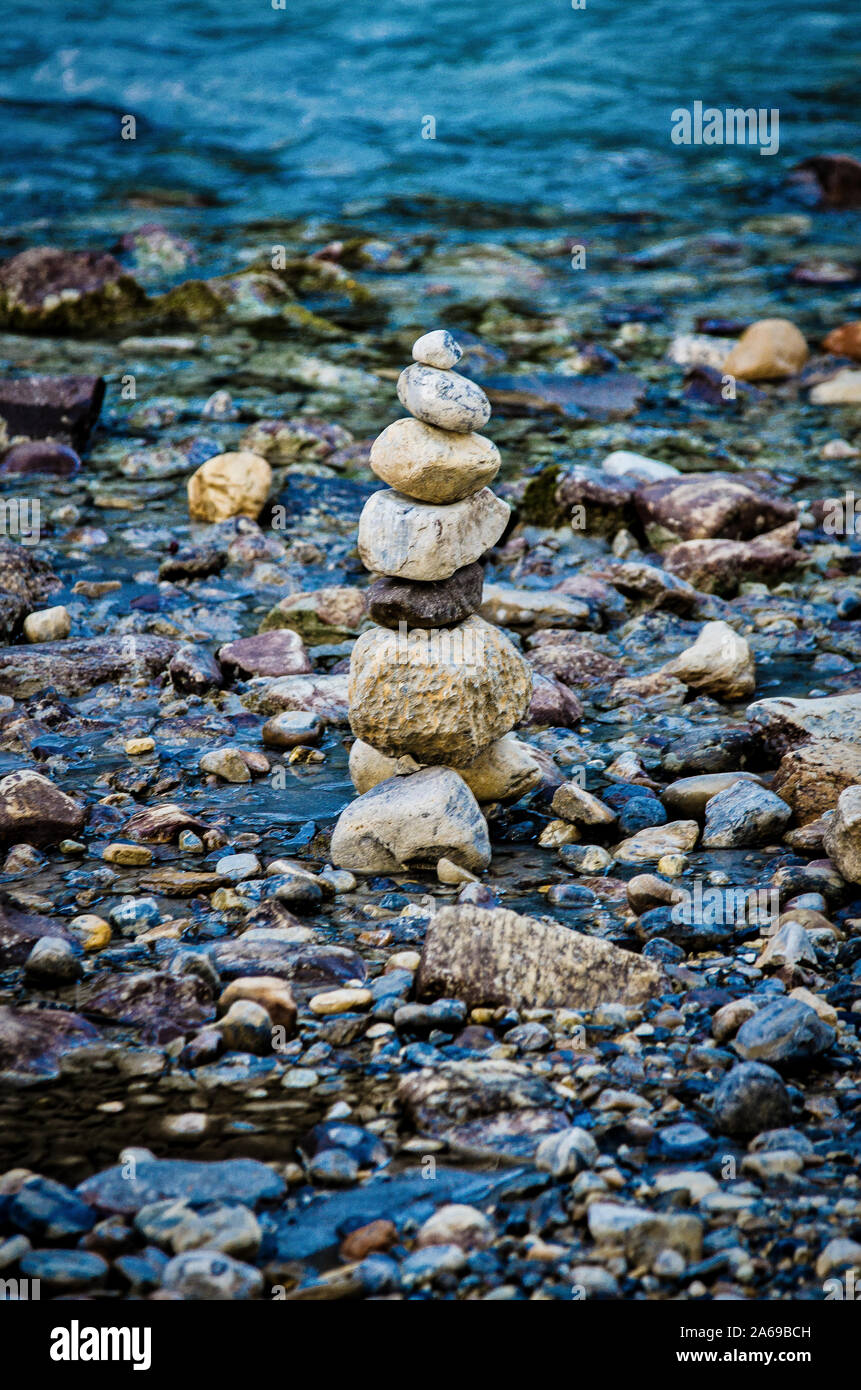 Equilibrato torre in pietra dalla riva di un fiume in Banff, Alberta Foto Stock