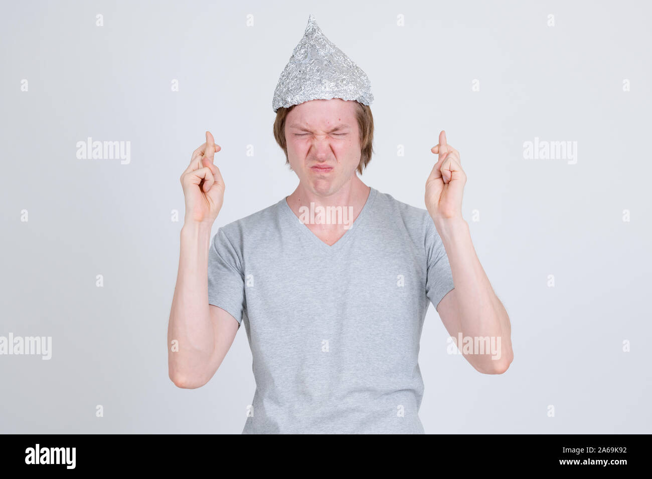 Giovane con foglio di stagno hat che desideri con le dita incrociate Foto Stock